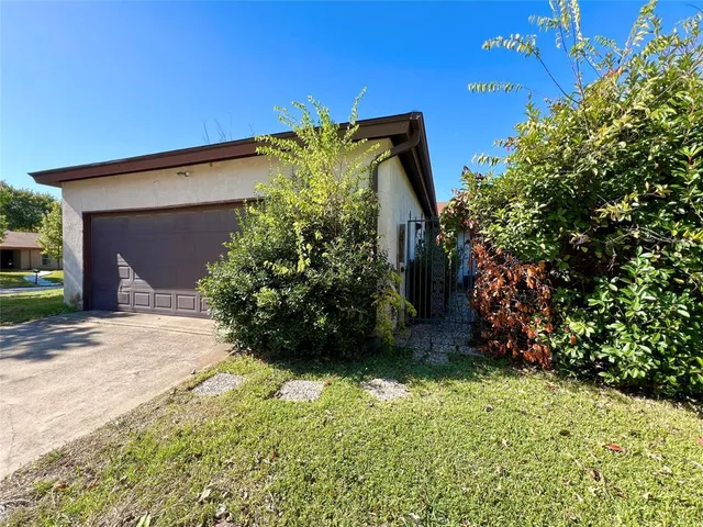 a view of a house with a yard and potted plants