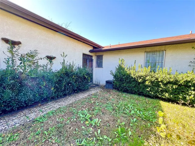 a backyard of a house with lots of green space and plants