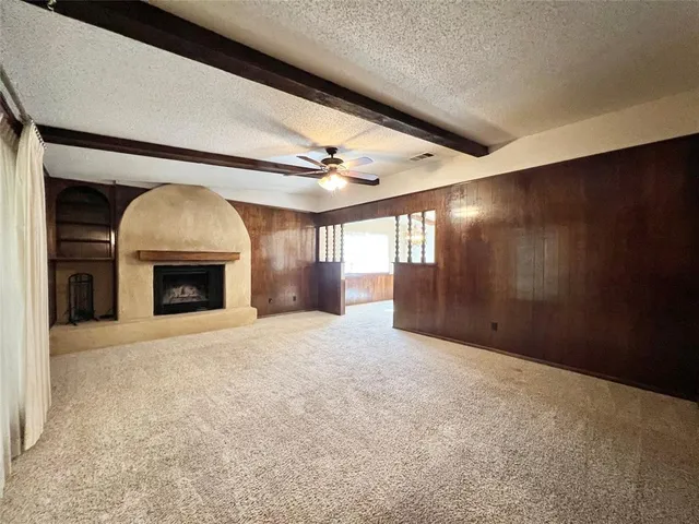 a view of an empty room with a fireplace and a window