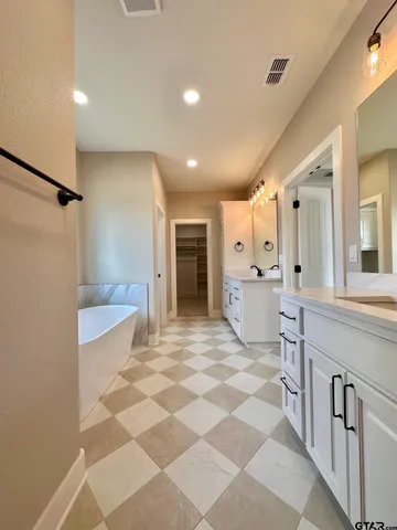 a large bathroom with a glass door shower and a sink