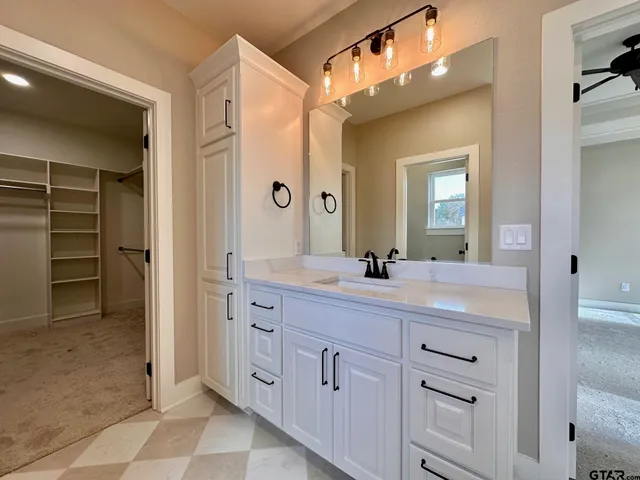 a spacious bathroom with a double vanity sink a large mirror and a shower