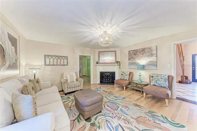 a view of a dining room with furniture wooden floor fireplace and a chandelier