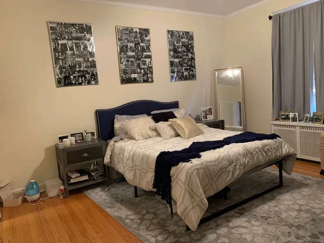 a bedroom with a bed a wall painting and a lamp