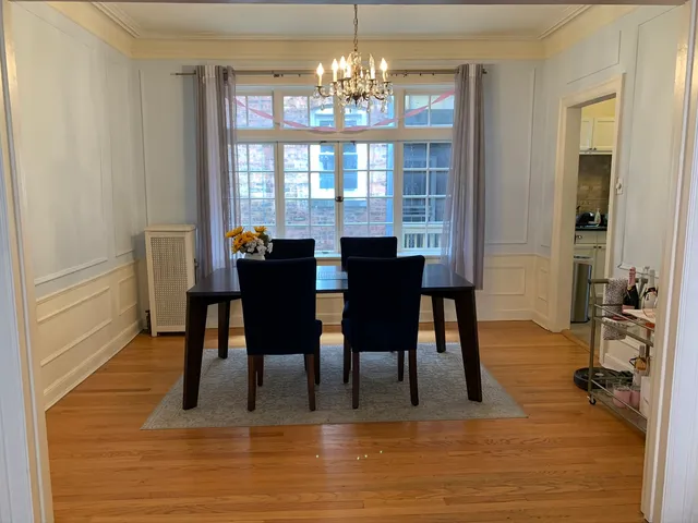 a view of a dining room with furniture a chandelier and wooden floor