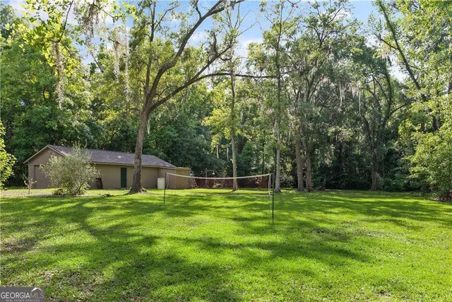 a backyard of a house with lots of green space and trampoline