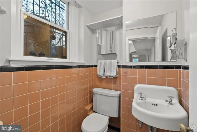 a bathroom with a toilet sink and mirror