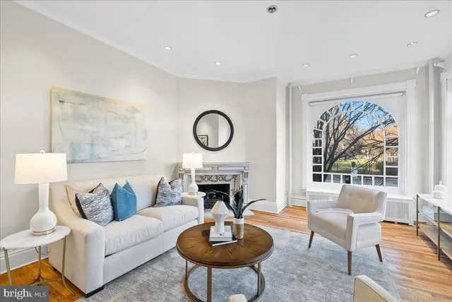 a living room with furniture a fireplace and a large window