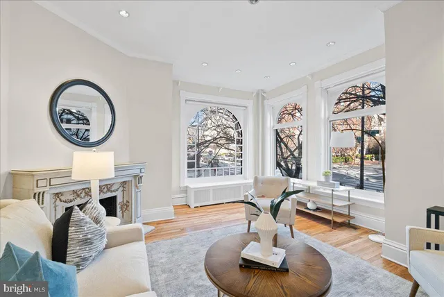 a living room with furniture a fireplace and a large window