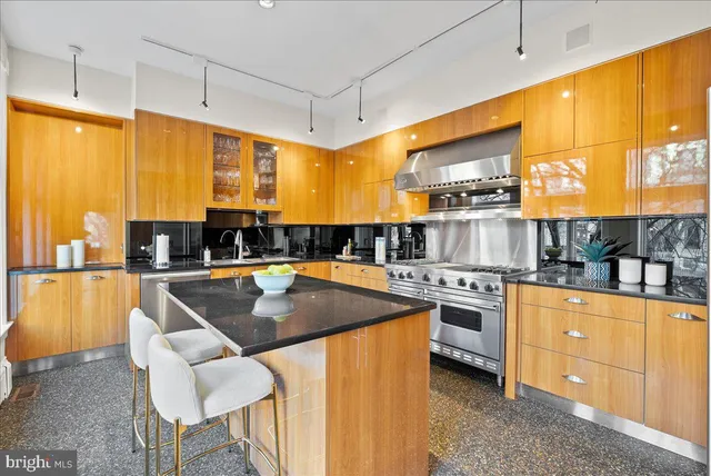 a kitchen with stainless steel appliances granite countertop a sink a stove and a refrigerator