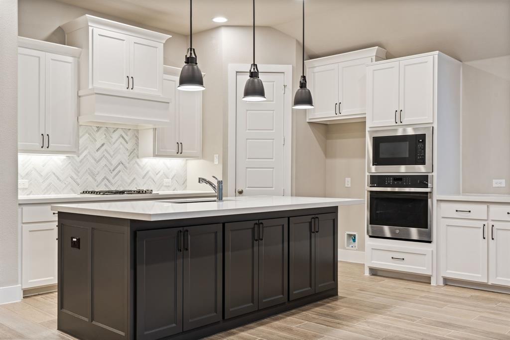 1314 Buttermere Street Forney, TX 75126 - Photo 7 of 32 a kitchen with stainless steel appliances granite countertop a sink a microwave a refrigerator and white cabinets with wooden floor