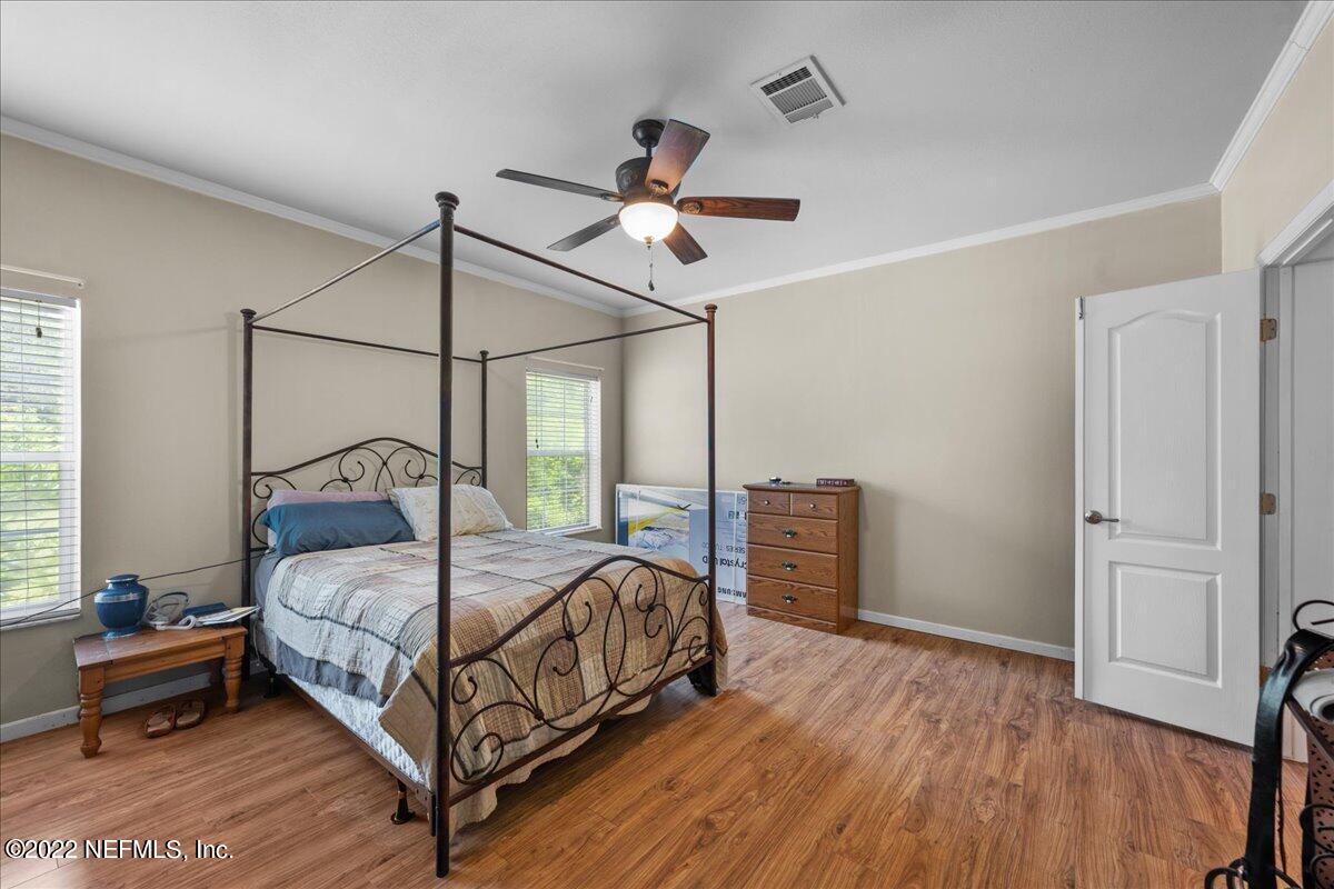 101 Sand Lake Road Interlachen, FL 32148 - Photo 11 of 40 a bedroom with a bed and a chandelier