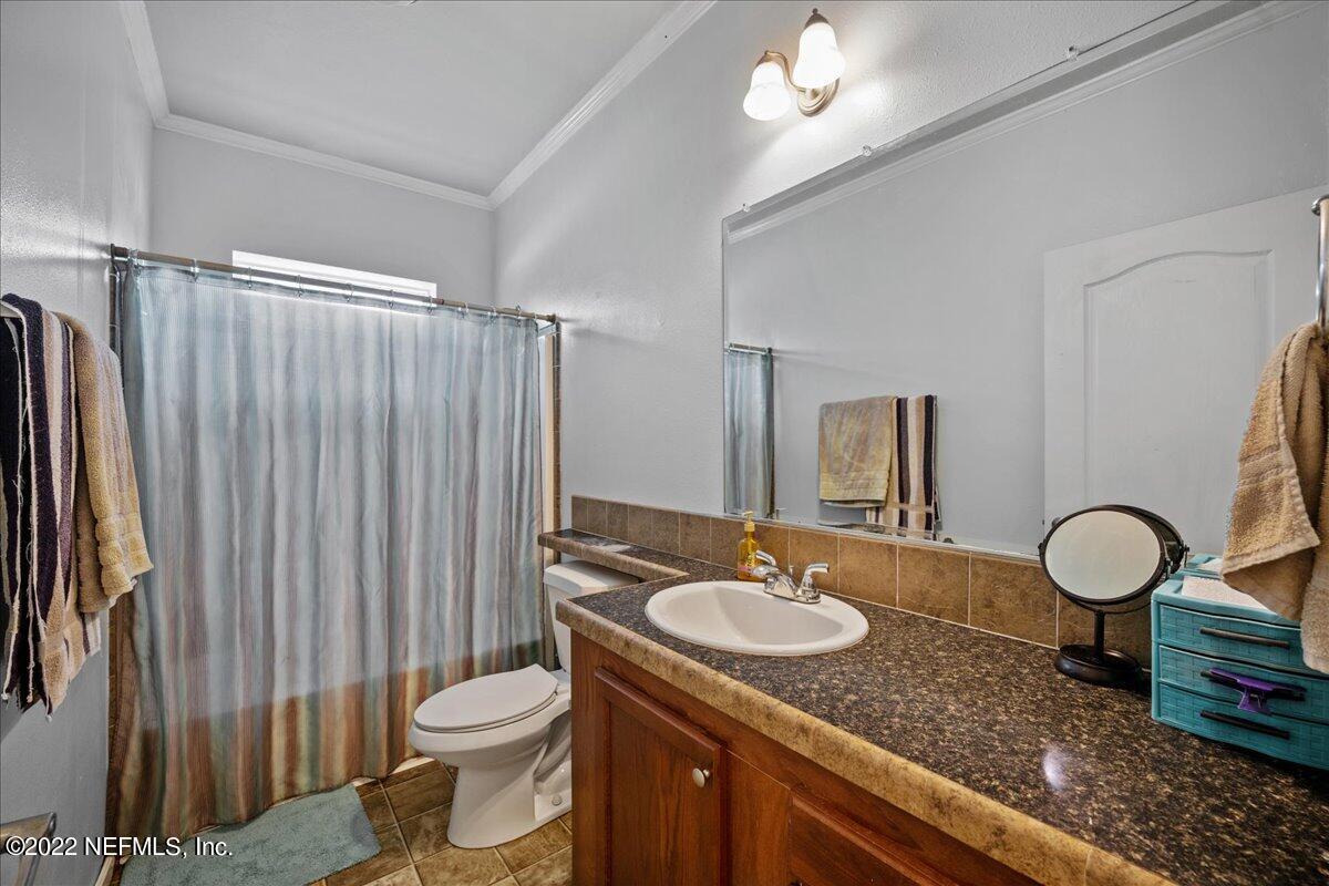 101 Sand Lake Road Interlachen, FL 32148 - Photo 17 of 40 a bathroom with a sink toilet a mirror and shower curtain