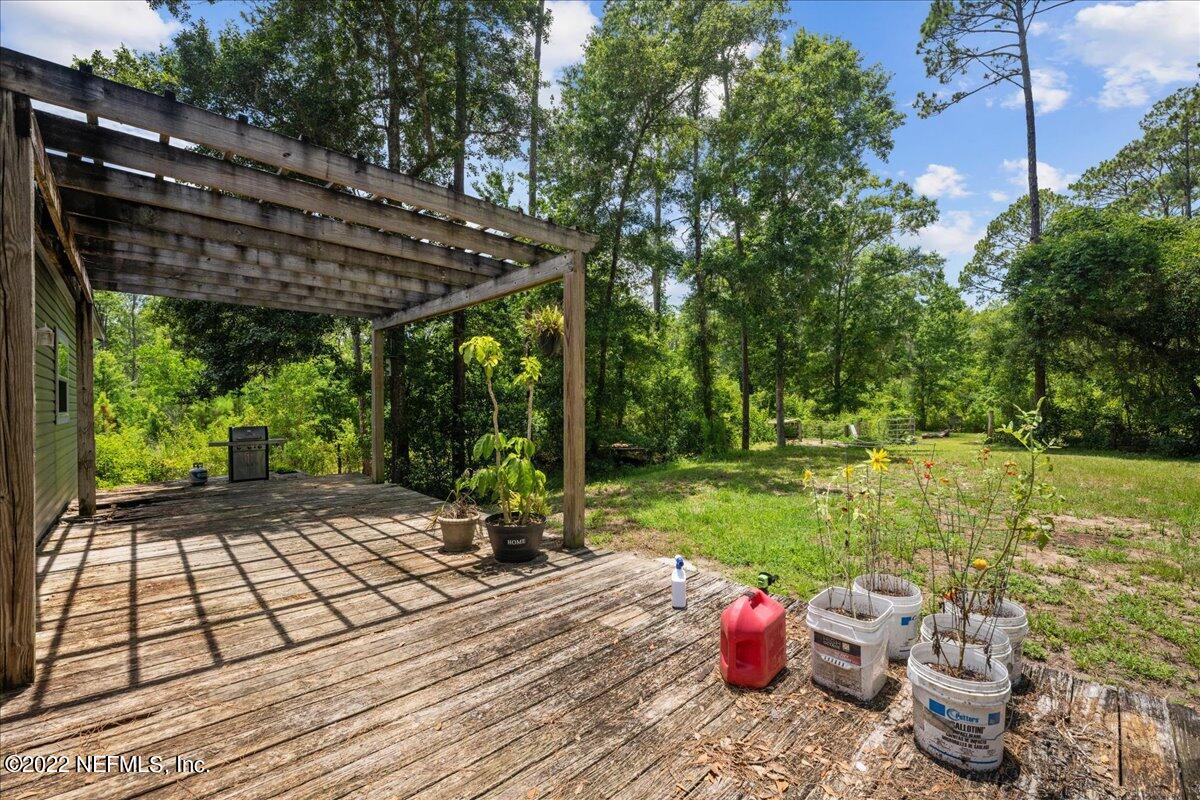 101 Sand Lake Road Interlachen, FL 32148 - Photo 24 of 40 a view of a patio with table and chairs potted plants and large tree