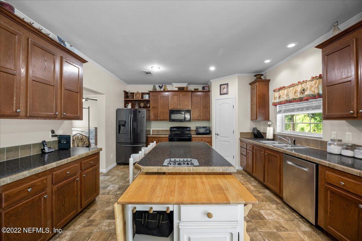 101 Sand Lake Road Interlachen, FL 32148 - Photo 3 of 40 a large kitchen with stainless steel appliances granite countertop a large stove top oven a sink dishwasher and cabinets with wooden floor