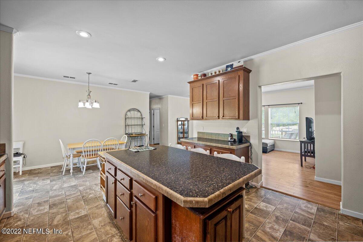 101 Sand Lake Road Interlachen, FL 32148 - Photo 4 of 40 a kitchen with granite countertop a table chairs sink and cabinets
