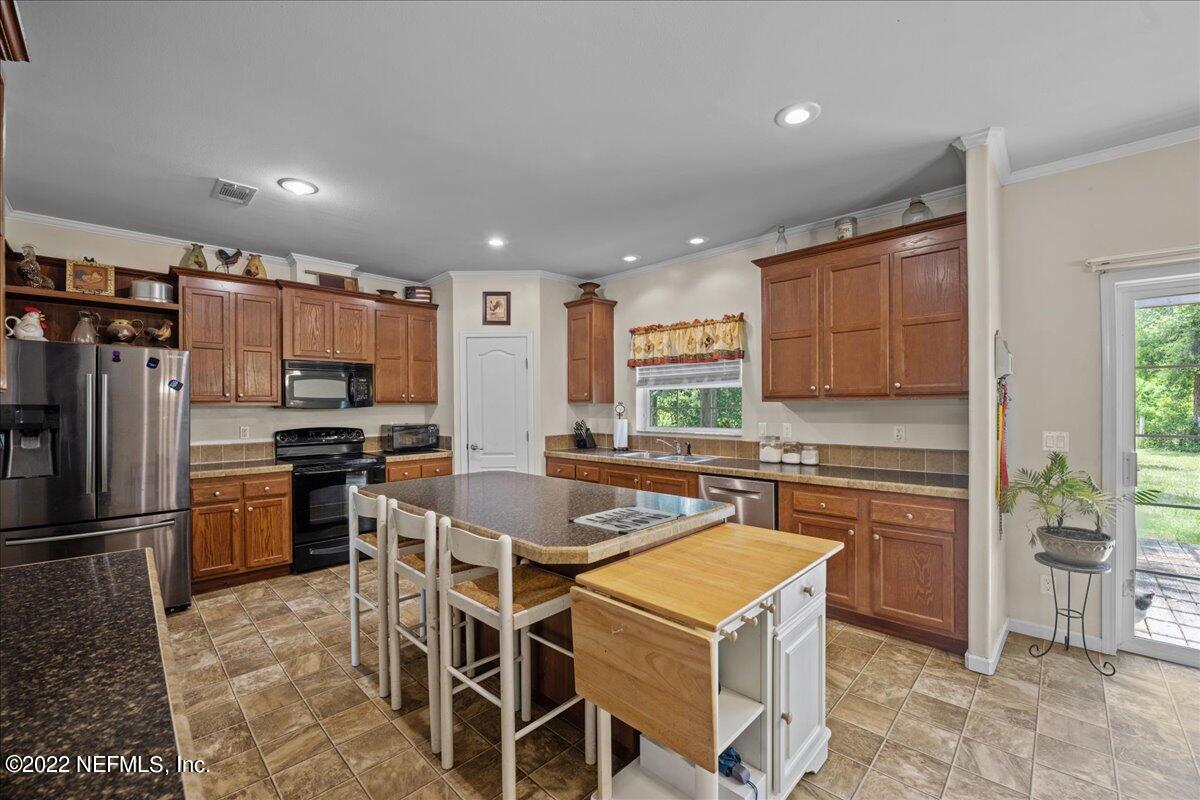 101 Sand Lake Road Interlachen, FL 32148 - Photo 6 of 40 a kitchen with a refrigerator a stove top oven a sink and cabinets
