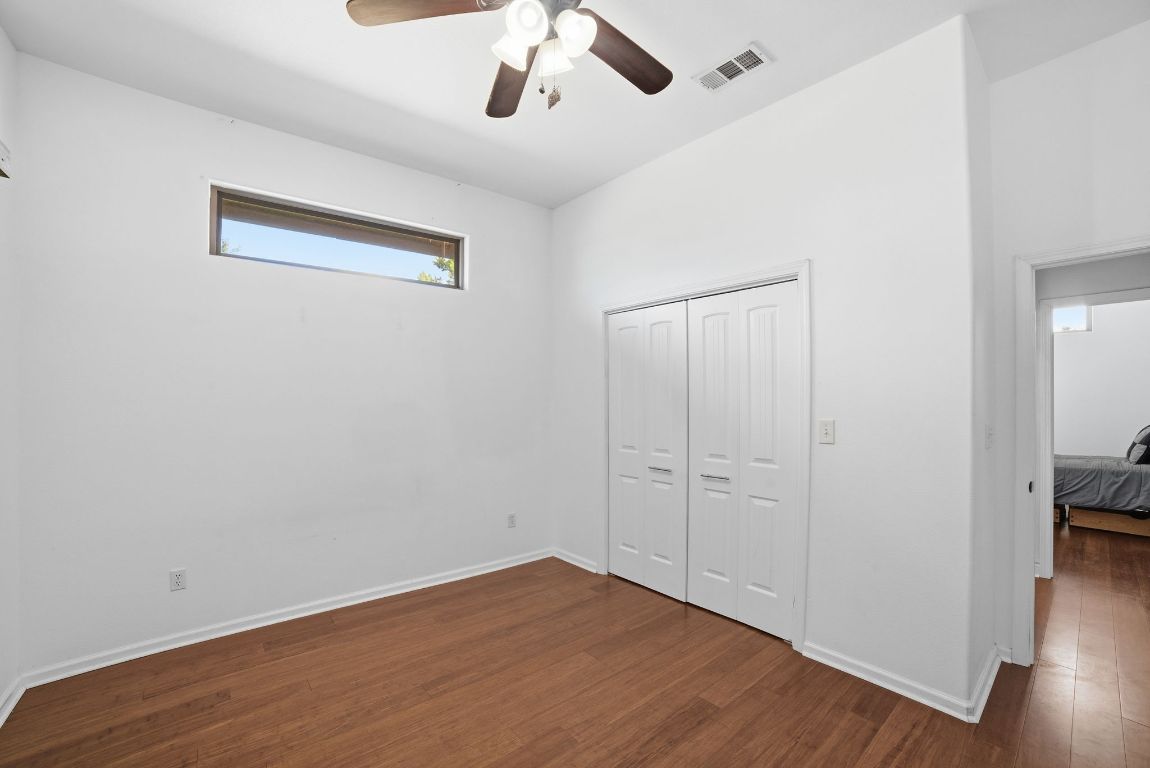 5704 Roundup Street Leander, TX 78645 - Photo 17 of 29 Unfurnished bedroom with dark wood-style flooring, a closet, and a ceiling fan