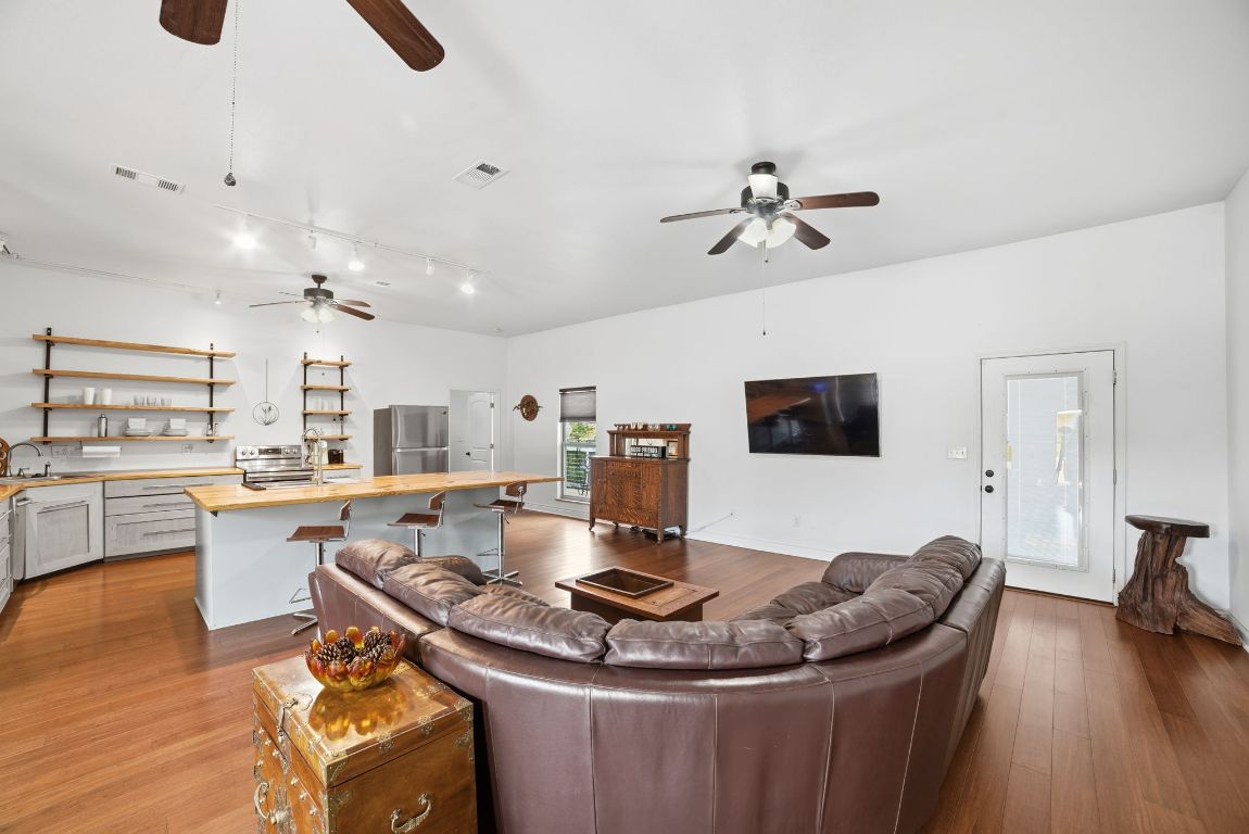 5704 Roundup Street Leander, TX 78645 - Photo 4 of 29 Living area featuring dark wood-style flooring and rail lighting
