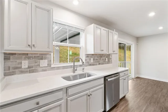 a kitchen with stainless steel appliances white cabinets and a stove top oven