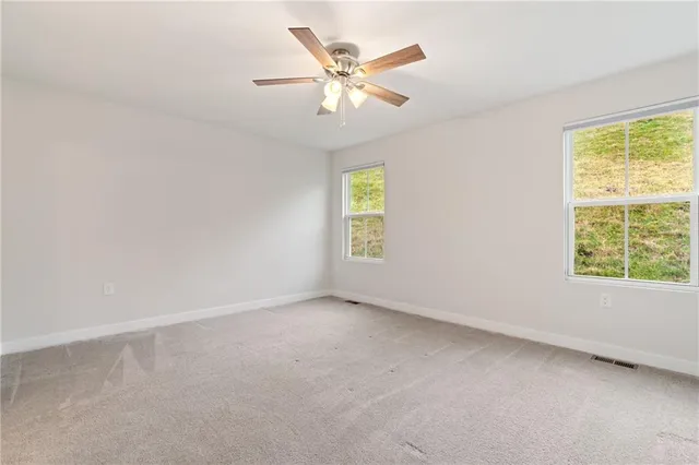 an empty room with chandelier fan