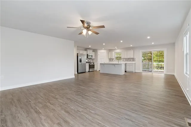 a view of empty room with wooden floor and window
