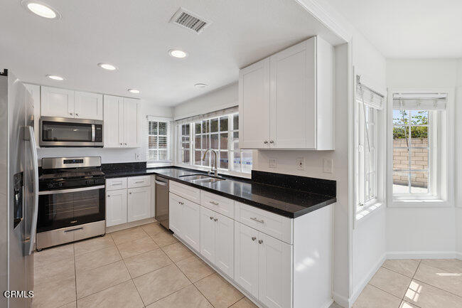 861 Dara Street Camarillo, CA 93010 - Photo 7 of 42 a kitchen with granite countertop white cabinets and stainless steel appliances