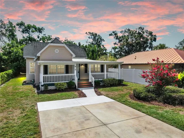 a view of house with garden and tall tress
