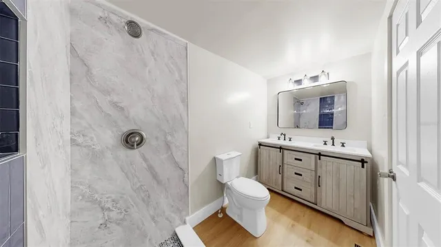 a bathroom with a double vanity sink mirror and toilet