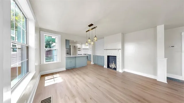 a view of a livingroom with a fireplace wooden floor and windows