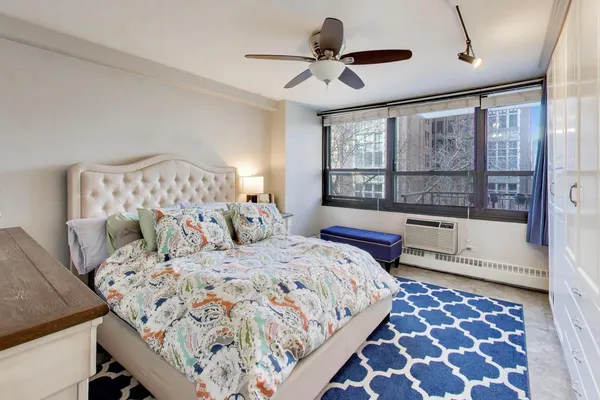 a bedroom with a bed and a lamp on dresser