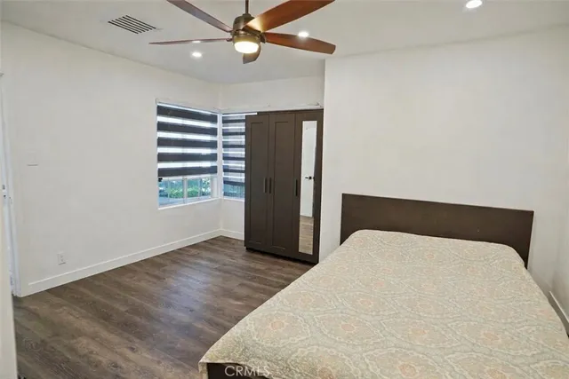 a large bed sitting in a bedroom next to a window and a chandelier