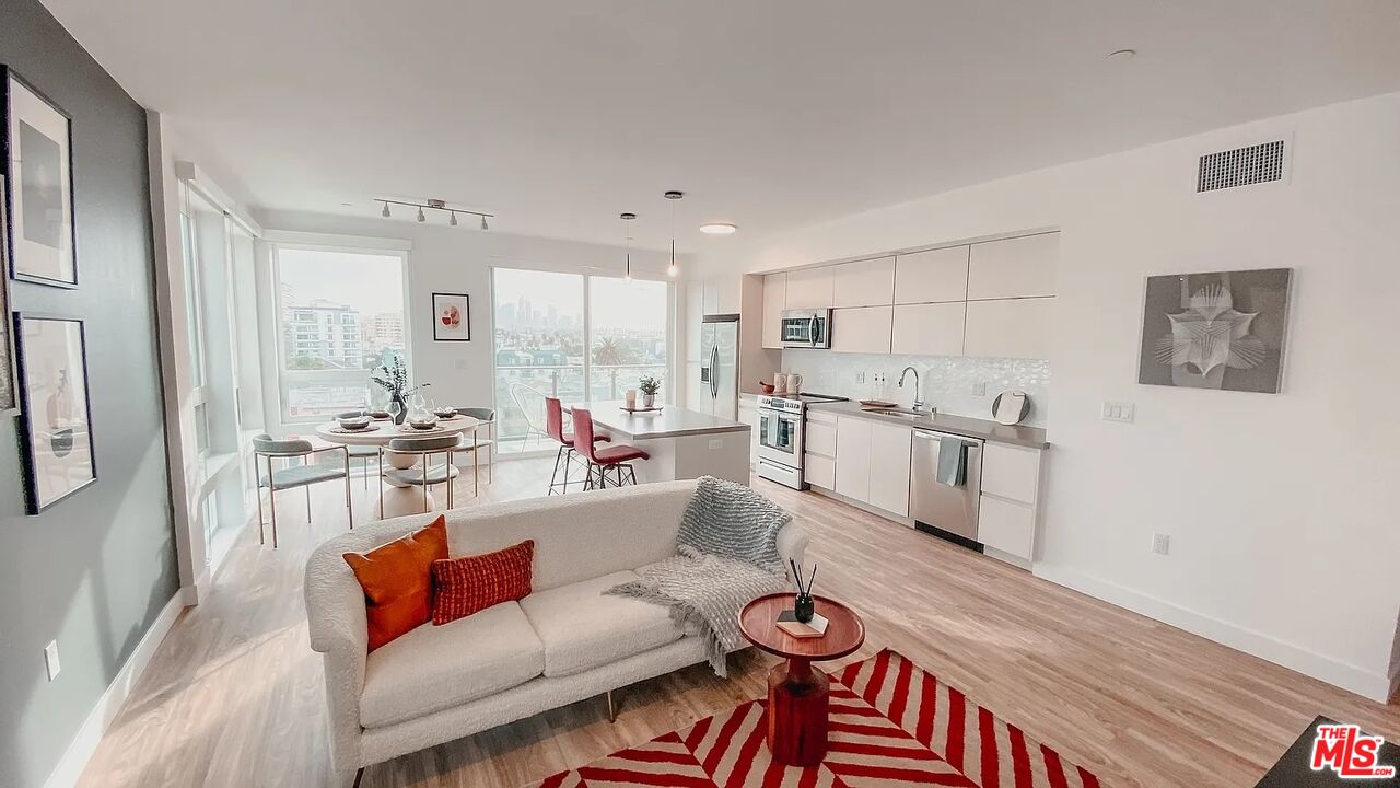 a living room with furniture and kitchen view