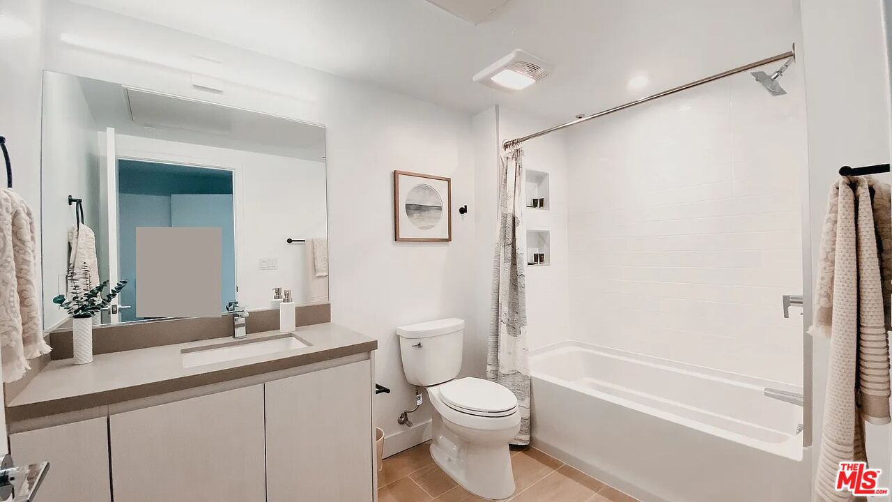 700 South Manhattan Place, Unit 513 Los Angeles, CA 90005 - Photo 4 of 9 a bathroom with a granite countertop sink a toilet and shower