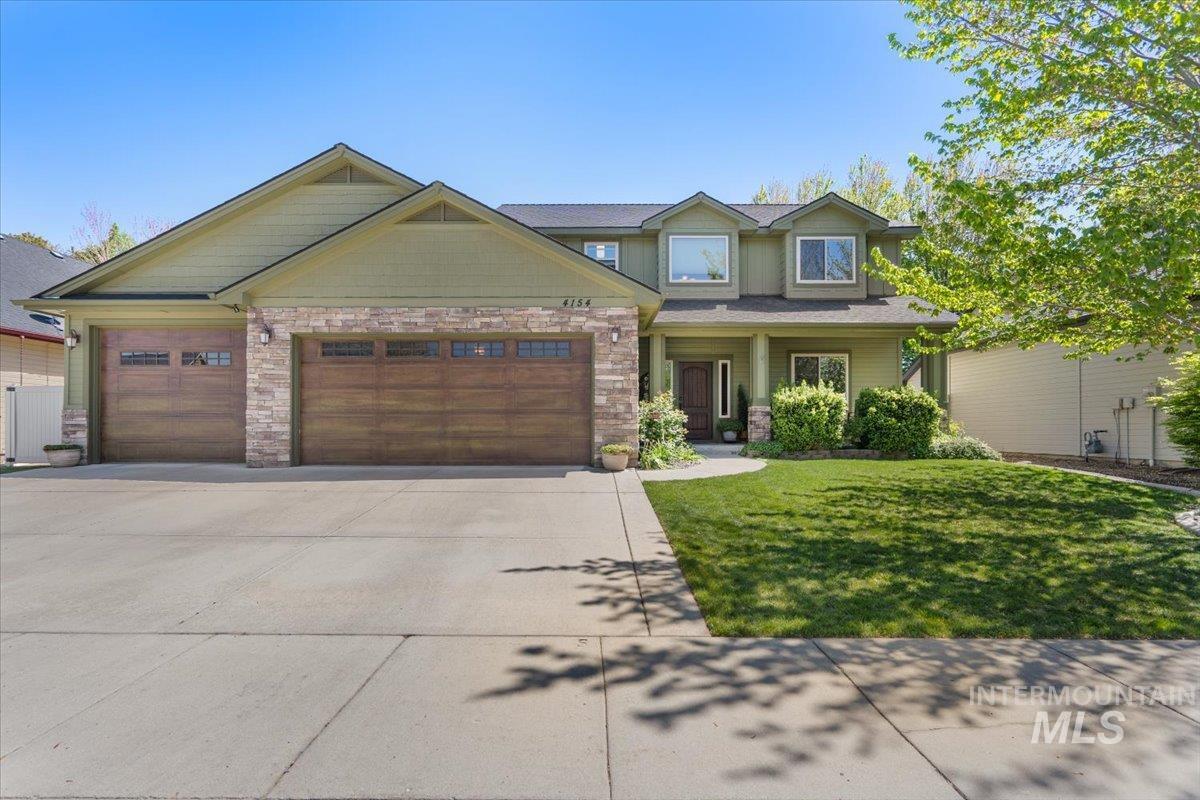 4154 North Tipton Avenue Meridian, ID 83646 - Photo 1 of 50 Two-story home featuring a green exterior, stone accents, and a covered front entry