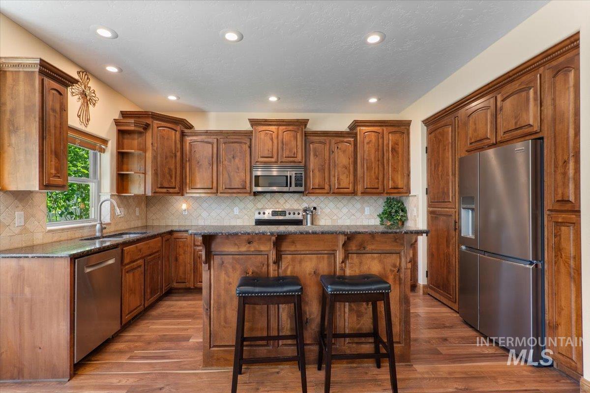 4154 North Tipton Avenue Meridian, ID 83646 - Photo 11 of 50 Well-appointed kitchen featuring rich wood cabinetry and a central island with bar seating