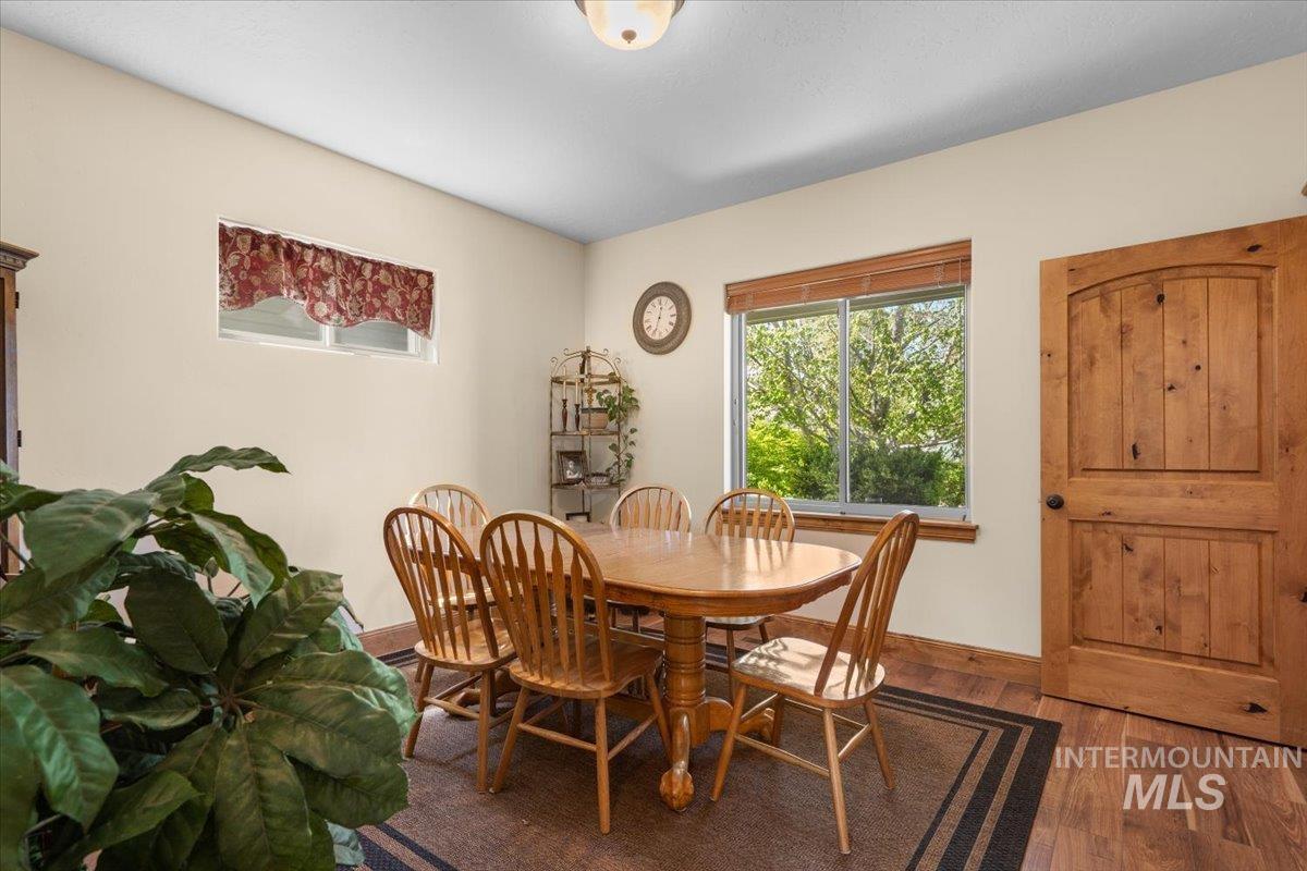 4154 North Tipton Avenue Meridian, ID 83646 - Photo 17 of 50 Dining area featuring wood-finish flooring, a large window with natural light, and a solid wood door