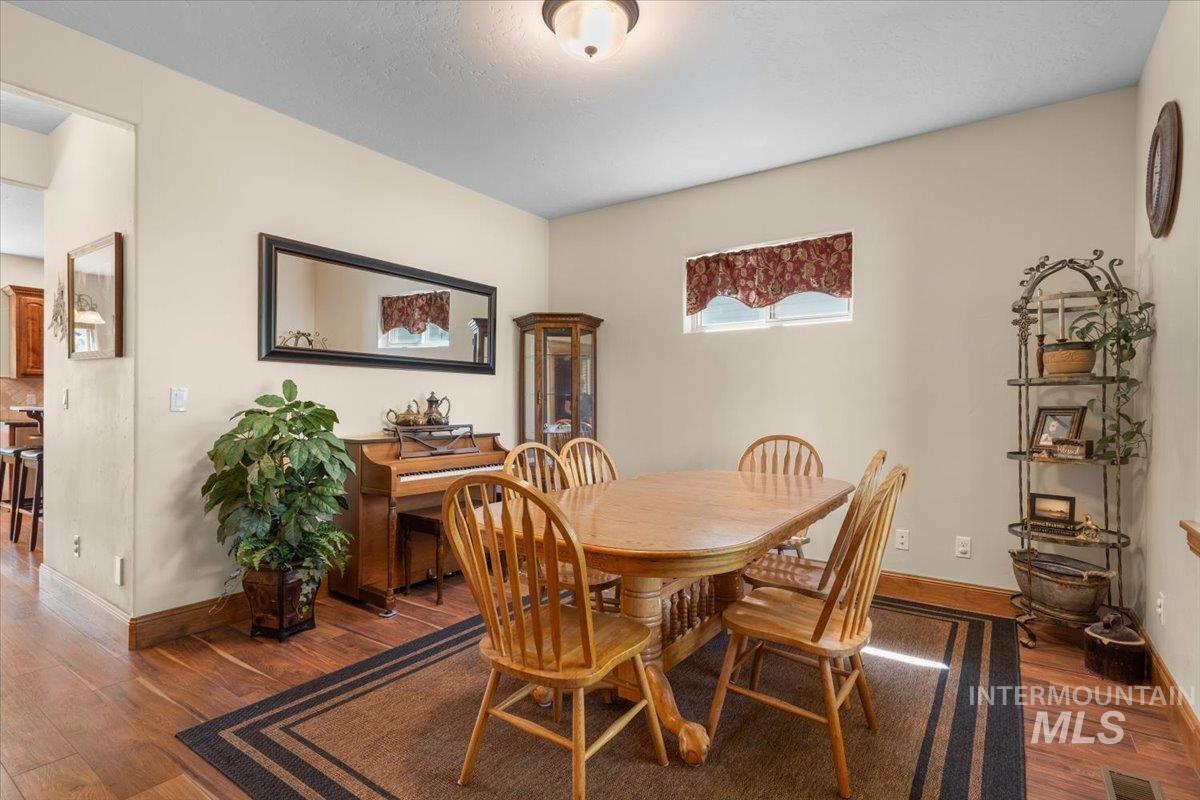 4154 North Tipton Avenue Meridian, ID 83646 - Photo 18 of 50 Formal dining area featuring wood-finish flooring, neutral wall tones, and a built-in display cabinet