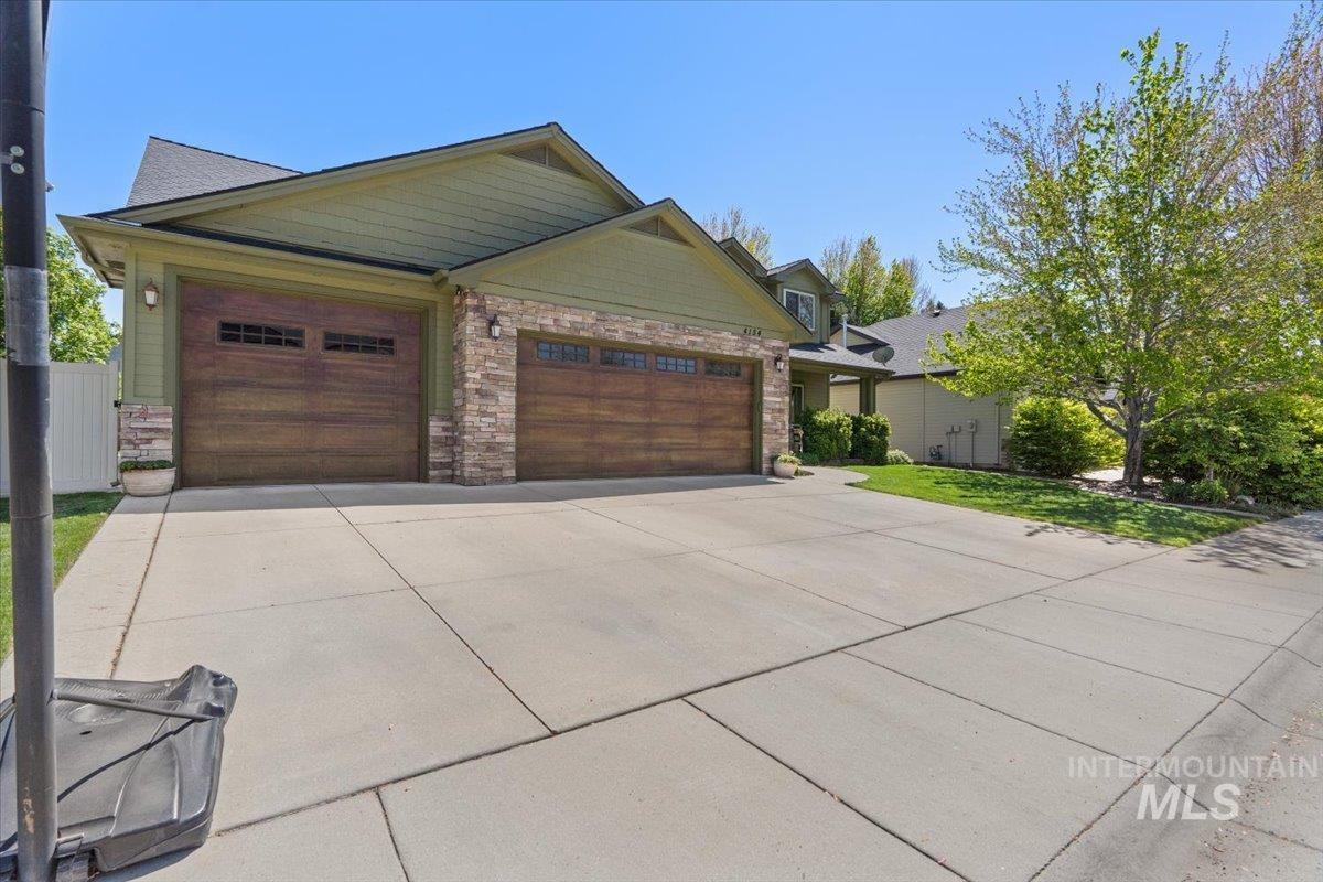 4154 North Tipton Avenue Meridian, ID 83646 - Photo 2 of 50 Exterior showcasing a two-car garage with wood-finish doors and transom windows