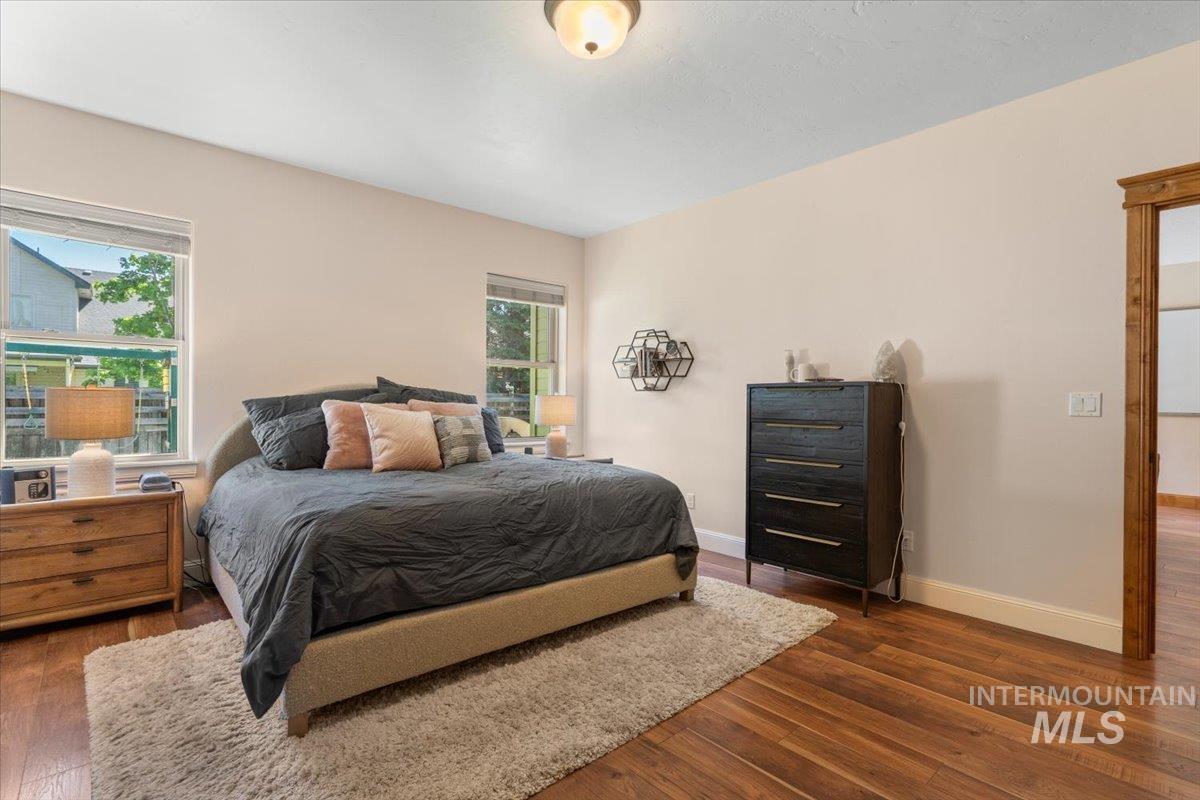 4154 North Tipton Avenue Meridian, ID 83646 - Photo 22 of 50 Bedroom featuring two windows, wood-finish flooring, light-toned walls, and a wood-trimmed doorway