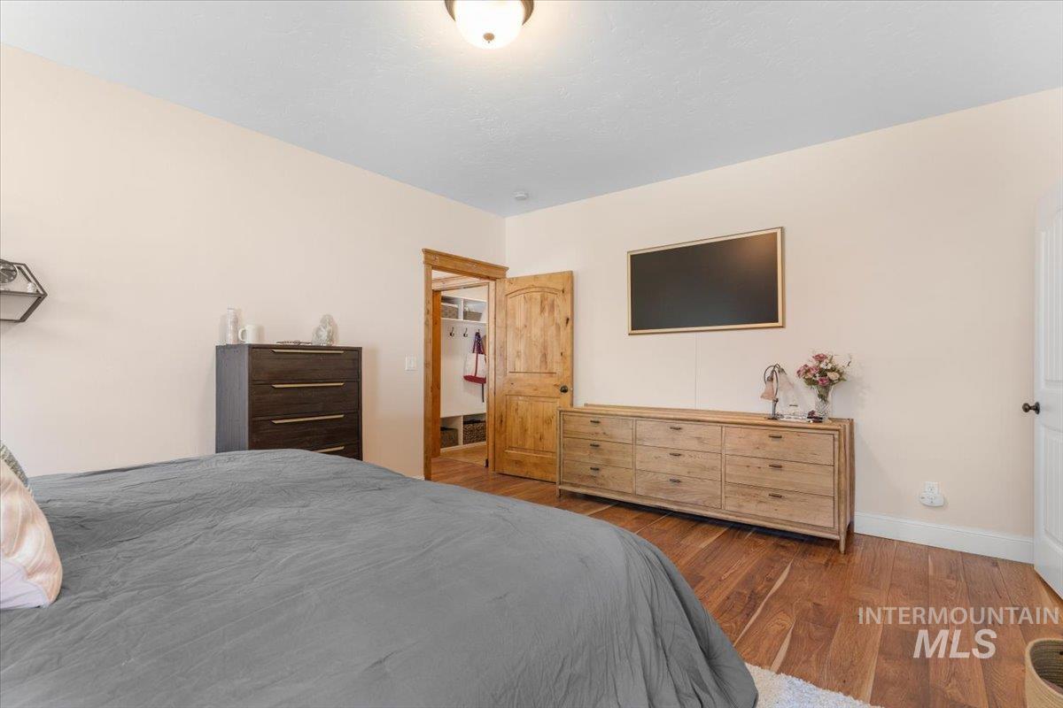 4154 North Tipton Avenue Meridian, ID 83646 - Photo 23 of 50 Room featuring wood-finish flooring, a wood-paneled door, and a recessed closet with built-in shelving