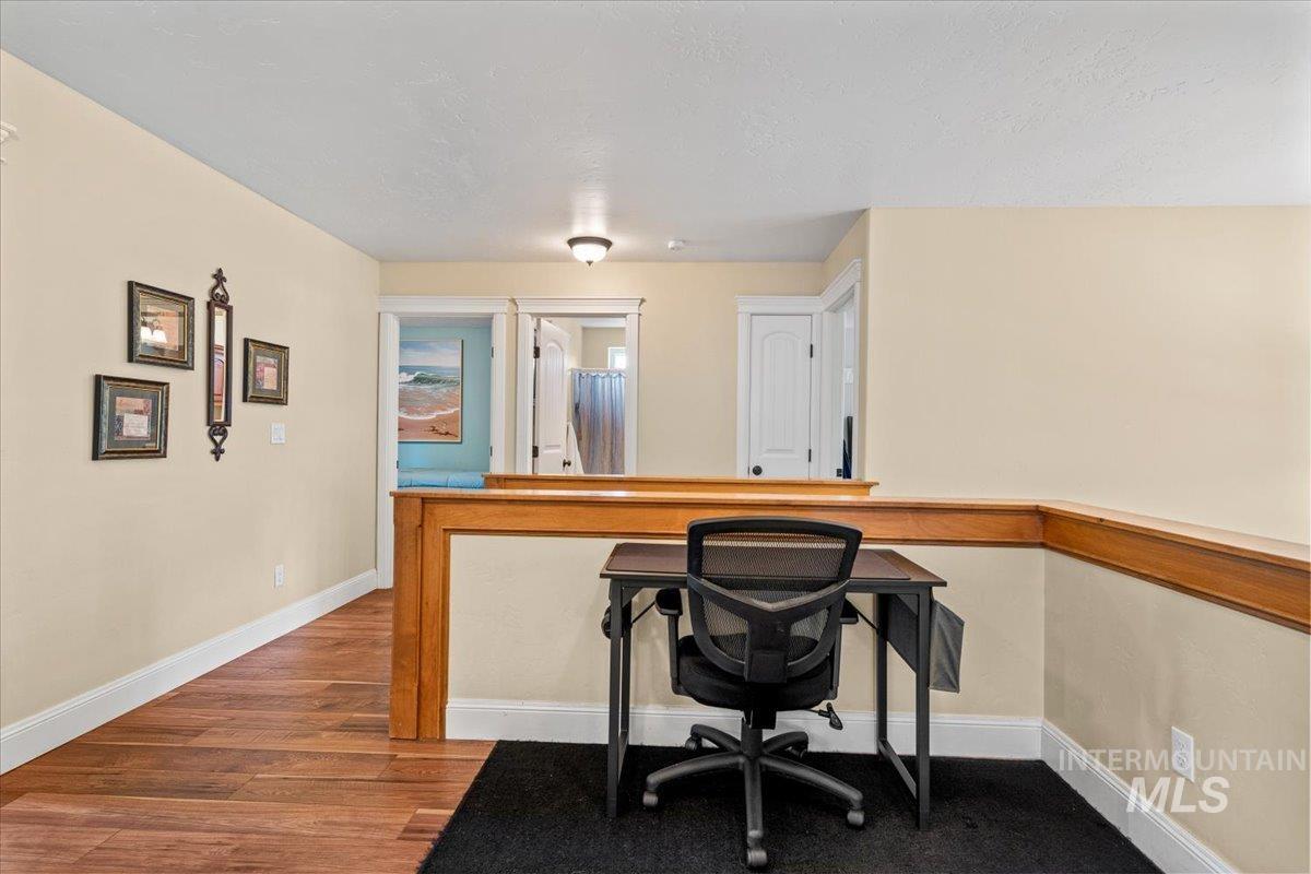 4154 North Tipton Avenue Meridian, ID 83646 - Photo 30 of 50 Open loft space featuring warm-toned walls, wood-finish flooring, white trim, and a wood railing
