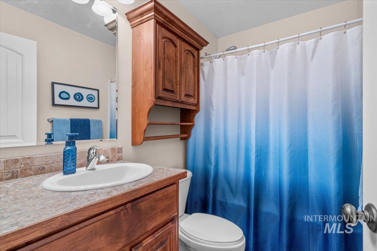4154 North Tipton Avenue Meridian, ID 83646 - Photo 38 of 50 Vanity with integrated sink, stone-look countertop, and tile backsplash