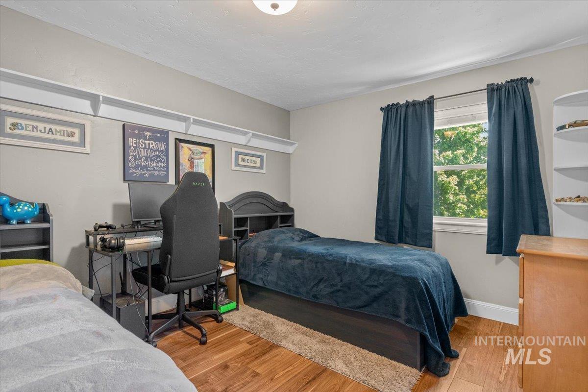 4154 North Tipton Avenue Meridian, ID 83646 - Photo 39 of 50 Bedroom featuring wood-finish flooring, a window with natural light, and neutral wall tones