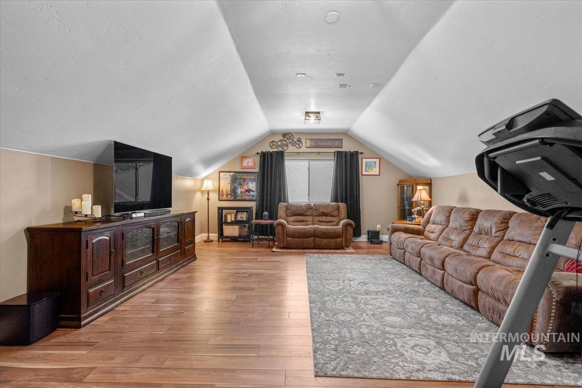 4154 North Tipton Avenue Meridian, ID 83646 - Photo 41 of 50 Spacious bonus room featuring wood-finish flooring, vaulted ceilings, and a built-in media console