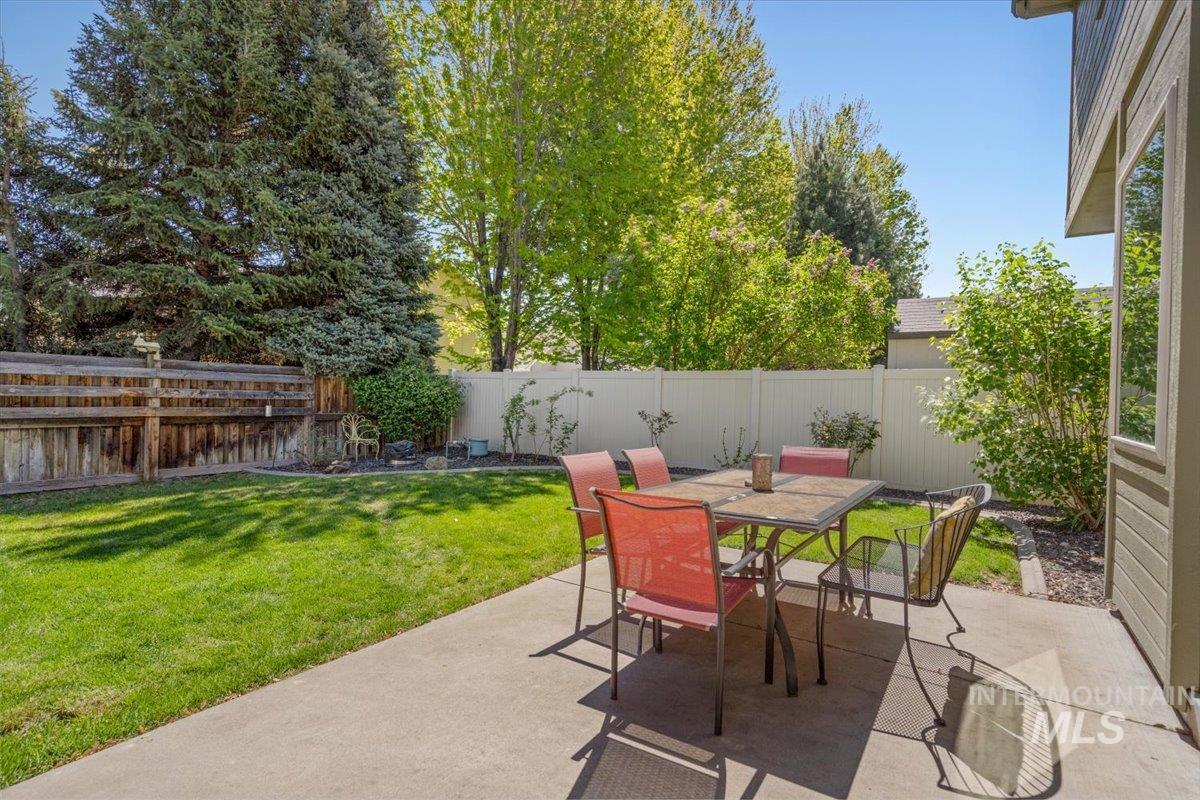 4154 North Tipton Avenue Meridian, ID 83646 - Photo 44 of 50 Concrete patio with a manicured lawn, established privacy fencing, mature trees, and landscaping