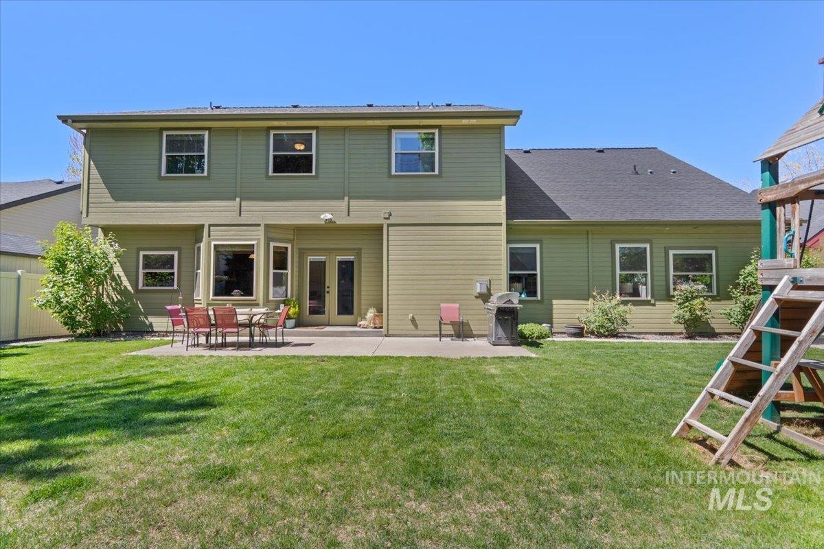 4154 North Tipton Avenue Meridian, ID 83646 - Photo 47 of 50 Spacious backyard with a large concrete patio, double glass doors, and multiple windows across the rear facade