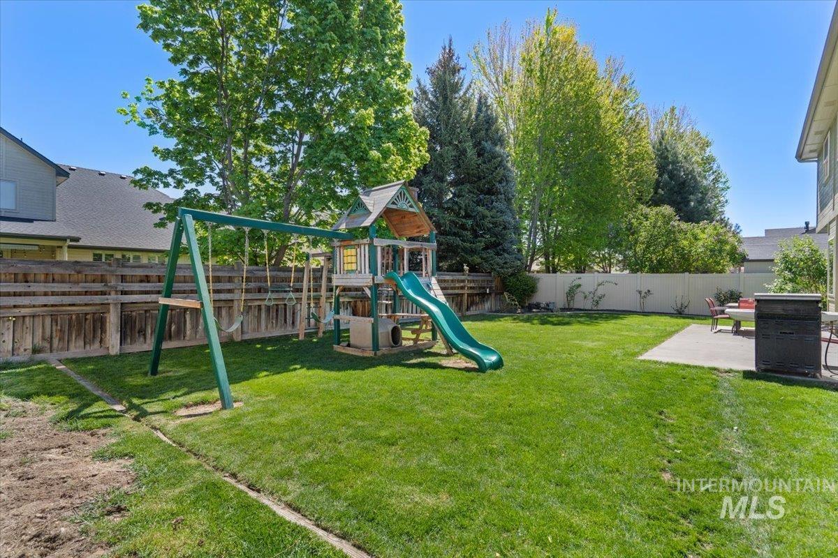 4154 North Tipton Avenue Meridian, ID 83646 - Photo 49 of 50 Spacious backyard featuring a large grass area, mature trees, a concrete patio, and wood fencing