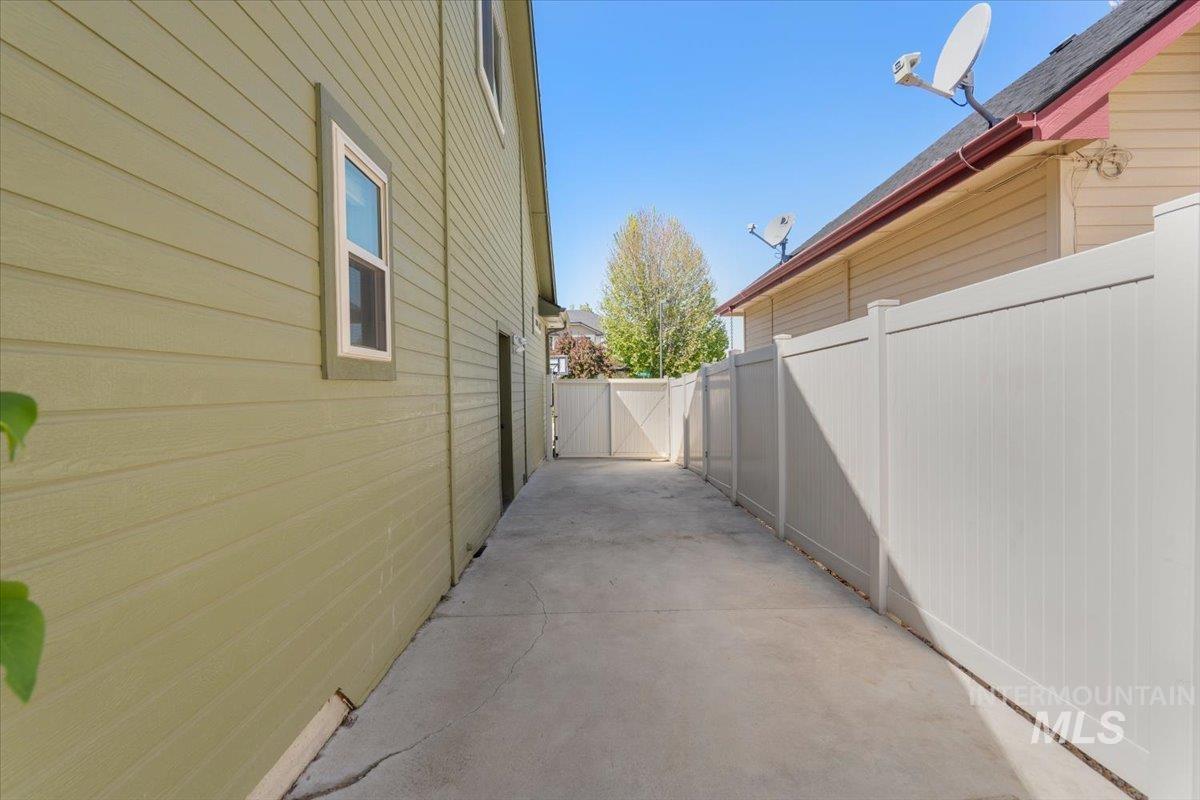 4154 North Tipton Avenue Meridian, ID 83646 - Photo 50 of 50 Concrete walkway featuring a full-height privacy fence, side access gate, and a secondary exterior door