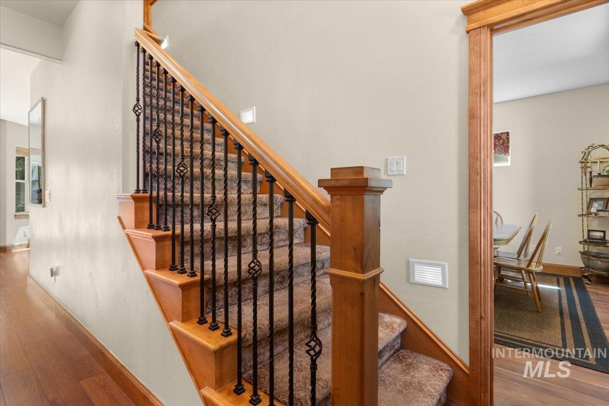 4154 North Tipton Avenue Meridian, ID 83646 - Photo 5 of 50 Staircase with wood newel posts, handrail, and wrought iron balusters featuring decorative twists