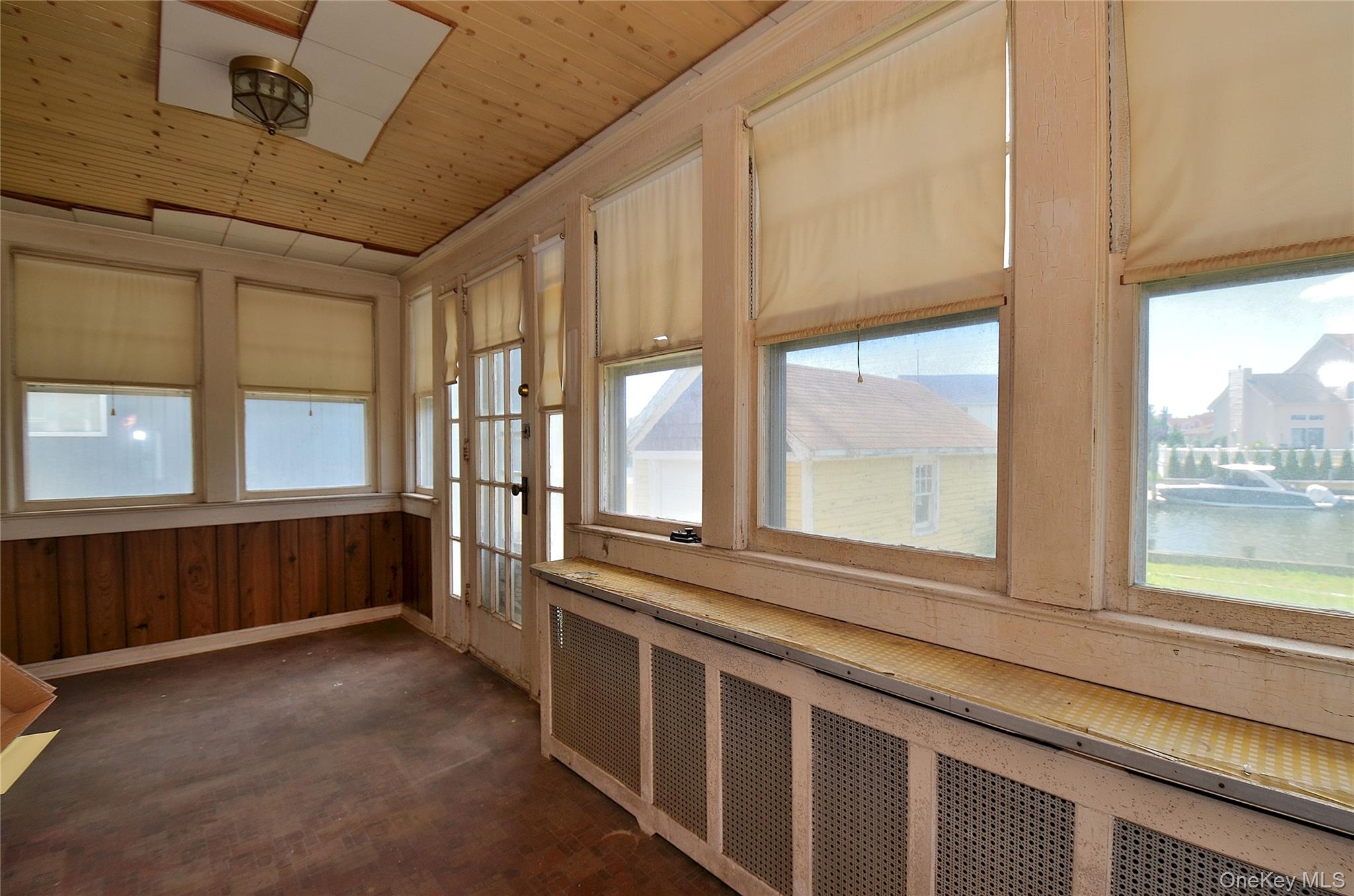 2586 Riverside Drive Wantagh, NY 11793 - Photo 27 of 28 Sunroom featuring wood-paneled walls, wood-finish flooring, and a wood-plank ceiling